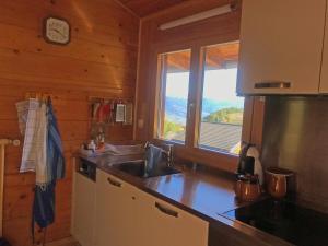 a kitchen with a sink and a window in a cabin at Les Tchaipus in Nendaz