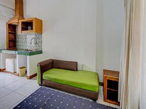 a couch with a green seat in a room at Super OYO Capital O 91810 Hotel Balebat 2 in Bandung