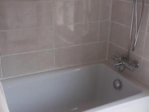 a white bath tub with a silver faucet in a bathroom at Domaine de gentilly la maison 