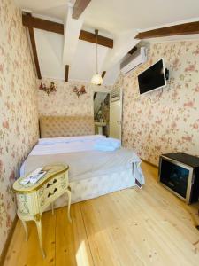 una camera con letto, tavolo e TV di Tatin - Hotel & Café in Mtskheta a Mtskheta