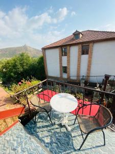 a patio with a table and chairs on a balcony at Tatin - Hotel & Café in Mtskheta in Mtskheta
