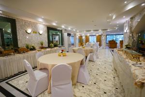 a banquet hall with white tables and white chairs at Ambassador Suites in Jeddah