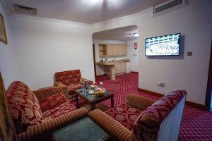 a living room with couches and a table and a television at Ambassador Suites in Jeddah