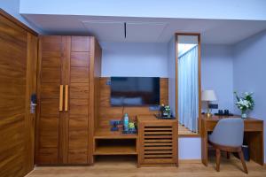 a living room with a desk and a television at Visthara Hotel in Bengaluru