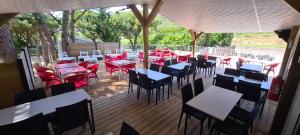 un restaurante con mesas y sillas en una terraza en Ushuaïa Villages Camping Figurotta en Bizanet