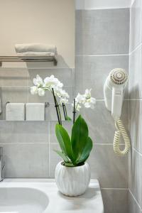 a bathroom with a sink with a phone and a plant at Rhome Guest House in Rome