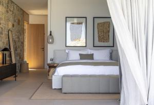 1 dormitorio con cama blanca y cortina blanca en Untold Mykonos, en Mykonos ciudad