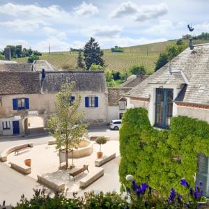 a view of a courtyard with benches and trees at Hôtel Restaurant Famille Bourgeois "La Cote des Monts Damnés" in Sancerre