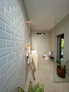 a bathroom with a toilet and a glass wall at Anchor Bed & Bread in Kuta Lombok