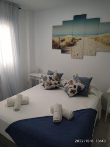 een bed met kussens en handdoeken erop bij Brisas del Medano in El Médano