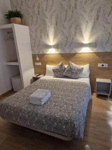 Un dormitorio con una cama con dos almohadas encima. en Hostal Esparteros, en Madrid