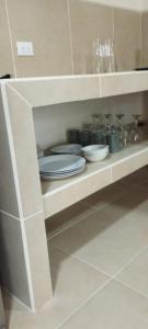 a shelf with plates and dishes on it in a kitchen at Cabinas Coconut Grove in Puerto Viejo