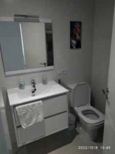 een badkamer met een toilet, een wastafel en een spiegel bij Brisas del Medano in El Médano