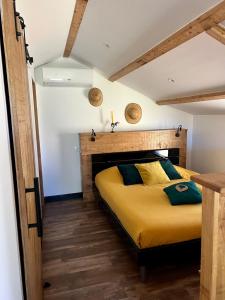 a bedroom with a large yellow bed in a room at Le Studio des Gîtes Aérostier in La Roque-Gageac