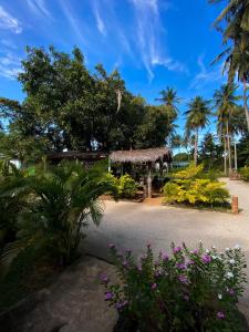 a garden with a gazebo with trees and flowers at Elena Garden Resort and Restaurant in Trincomalee
