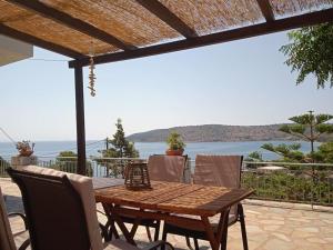 een houten tafel en stoelen met uitzicht op de oceaan bij Kamares View in Ayeranós