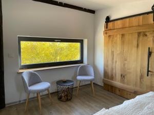 a bedroom with two chairs and a flat screen tv at Deichgraf „Die Elbpension“ in Dornburg