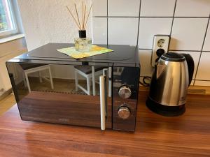 einen Tisch mit einer Mikrowelle und einer Kaffeemaschine auf dem Boden in der Unterkunft Möblierte 1-Zimmer Wohnung im Zentrum Ottersbergs für Monteure und geschäftlich Reisende in Ottersberg