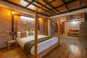 a bedroom with a bed and a brick wall at THE CEDAR CASTLE in Mukteswar