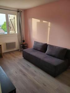 un soggiorno con un divano e una finestra di Appartement moderne et équipé a LʼIsle-Jourdain
