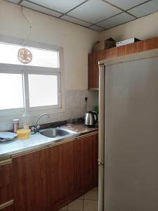 eine Küche mit einer Spüle und einem Kühlschrank in der Unterkunft OMAR Vacation in Dubai