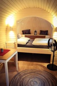 a room with a bed with a fan and a table at Tiny House Kotten Kunterbunt in Nottuln