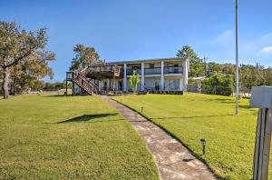 a house with a grassy yard in front of it at Spacious Livingston Home with Private Boat Dock in Livingston