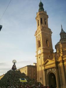 un gran edificio con una torre de reloj con una pila de flores en Apartamento el Pilar 4, en Zaragoza