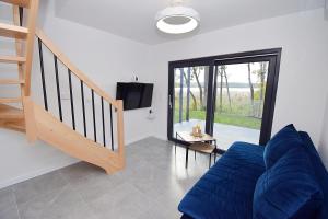 ein Wohnzimmer mit einem blauen Sofa und einer Treppe in der Unterkunft Gwiazda Kaszub in Chmielno