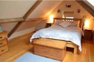 a bedroom with a bed and a wooden floor at The Barn - Yorkshire Coast Holiday Lets in Whitby