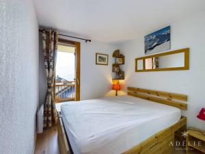 a bedroom with a white bed and a window at Appartement Montvalezan-La Rosière, 2 pièces, 4 personnes - FR-1-398-617 in Montvalezan