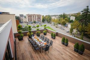 een balkon met een tafel en stoelen en een straat bij Hotel InnDigo in Kutaisi in Koetaisi