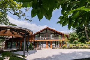 ein großes Holzgebäude mit einem großen Fenster in der Unterkunft Resort CATTALEYA in Čeladná