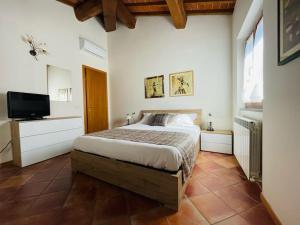 a bedroom with a bed and a flat screen tv at A duecento passi- comfort nel cuore della Toscana in San Giovanni Valdarno
