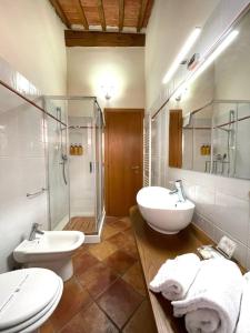 a bathroom with two sinks and a shower and a toilet at A duecento passi- comfort nel cuore della Toscana in San Giovanni Valdarno