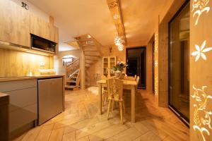 a kitchen and living room with a table and a staircase at Domek Zakopiański Czar 2 in Zakopane