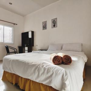 a white bed with two donuts on top of it at De​ Lanta place in Ko Lanta