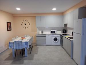 a kitchen with white appliances and a table with chairs at la vall in Caserío Abdet