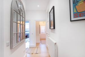 un corridoio con pareti bianche e uno specchio sul muro di Meadowbank Residence 3bed free parking a Edimburgo