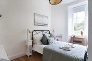 a white bedroom with a bed and a window at Meadowbank Residence 3bed free parking in Edinburgh