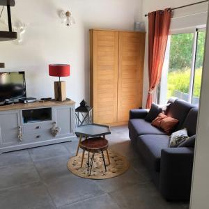 a living room with a couch and a table at Maison au cœur des étangs de Sologne avec SPA , Domaine de Sainte-Marie in Ardon