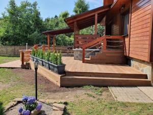 a house with a wooden deck next to a building at Chata Damal pri Liptovskej Mare in Žiar