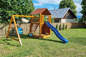 a playground with a slide and a play house at Chata Damal pri Liptovskej Mare in Žiar