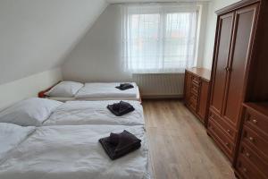 a bedroom with two beds with black towels on them at Chata Damal pri Liptovskej Mare in Žiar