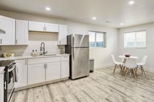 a kitchen with white cabinets and a stainless steel refrigerator at West Valley City Duplex about 13 Mi to Downtown SLC! in West Valley City