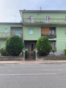 um edifício verde com uma varanda numa rua em Casa Elodie em Bagnoregio