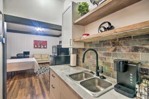 a kitchen with a sink and a room with a bed at Modern Greenwood Studio Less Than 1 Mi to Downtown! in Greenwood