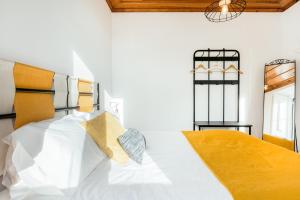ein Schlafzimmer mit einem Bett mit weißen Kissen in der Unterkunft Rustic City View Apartments in Baixa by River Tagus in Lissabon
