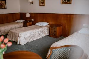 a hotel room with two beds and a chair at Apartamenty Gala in Sułkowice