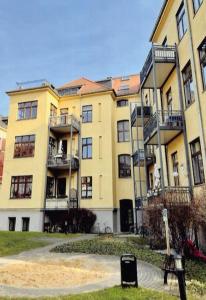 Traumhafte Wohnung im Herzen von Leipzig في لايبزيغ: مبنى اصفر كبير عليه بلكونات